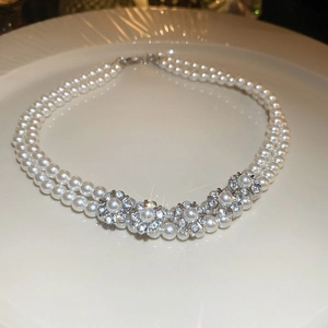 Detail of vintage double-layer pearl necklace with five sparkling rhinestone flowers
