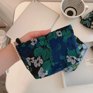 Close-up of dark green floral jacquard mini storage bag with a vintage texture