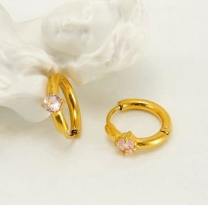 Détail de créoles plaquées or 18 carats avec un zircon rose vif serti griffes