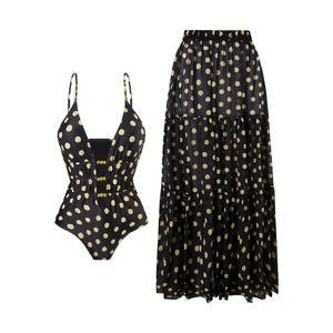 Deep V-neck swimsuit and tiered maxi skirt set featuring golden polka dots on black fabric