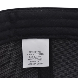 Gros plan de l'étiquette d'entretien d'une casquette d'hiver noire en 100% polyester