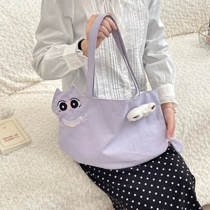 Detail of light purple canvas tote with cat face embroidery and white plush charm