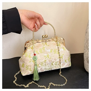 Detail of vintage beige satin handbag with floral embroidery and bamboo gold handle