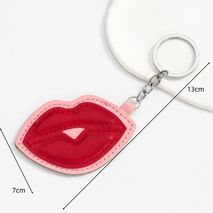 Red lip-shaped faux leather keychain with pink stitching, 13cm length, white background