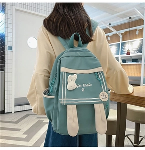 Close-up of green nylon backpack with white rabbit head decor and Fan Rabbit embroidery