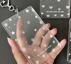 Detail of glitter acrylic card holder with star patterns and a heart-shaped metal clasp