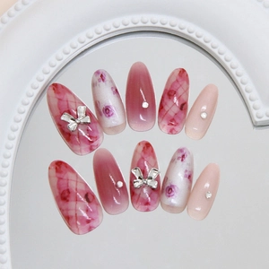Unghie finte sfumate rosa con fiocchi argentati e strass scintillanti eleganti