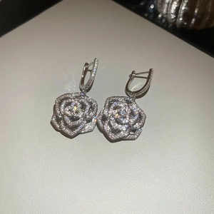 Macro detail of silver floral drop earrings with sparkling cubic zirconia pavé setting