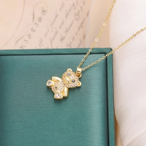 Golden teddy bear necklace with white crystal pavé and heart charms on satin
