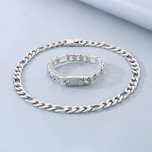 Dettaglio del set collana e bracciale Figaro in acciaio al titanio argento su sfondo blu