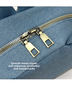 Detail of dual smooth bronze zippers on blue denim fabric with twill texture