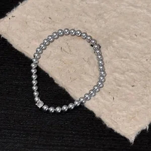 Detail of silver pearl bracelet with a sparkling crystal charm on a thank you card