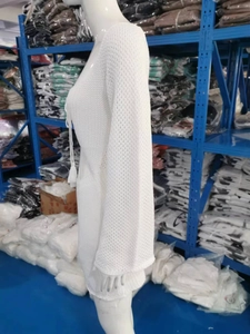 Detail of white crochet knit beach cover-up featuring hollow mesh and tassel neck ties