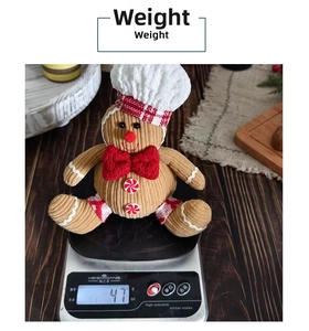 Plush gingerbread man on a digital scale showing a weight of approximately 47 grams