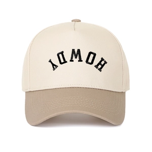 Close-up of black HOWDY embroidery on a cream and khaki cotton baseball cap