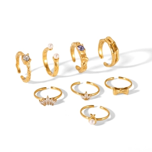 7-piece gold stackable ring set featuring bowknot, pearls, and crystals on textured metal