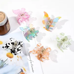 Flat lay of six colorful butterfly hair claws in marble and floral patterns on white background