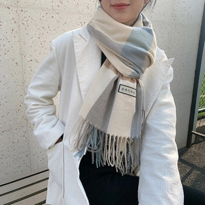 Close-up of beige blue plaid cashmere scarf with soft fringe and Korean design label
