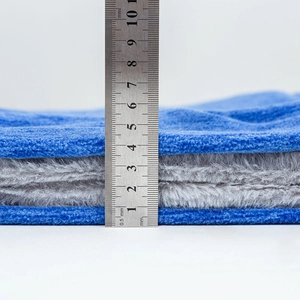 Thick blue and gray thermal winter hat showing 50mm thickness with a steel ruler