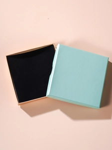 Close-up of square jewelry gift box with sky blue lid and soft pink base with foam insert