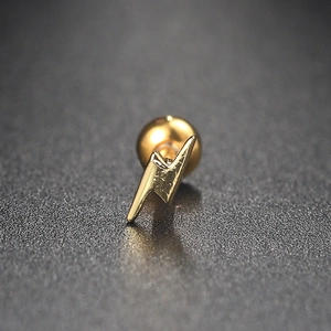 Detailed macro view of a golden lightning bolt stud earring with screw back ball closure