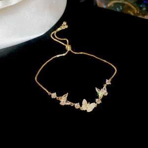 Close-up of a gold-plated adjustable bracelet with sparkling zircon butterfly charms