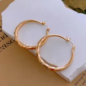Boucles d'oreilles créoles dorées avec motif losange martelé au style minimaliste