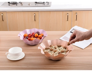 Detail of pink lotus leaf edge plastic fruit bowls in a modern kitchen setting