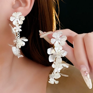 Boucles d'oreilles fleurs argentées sur mannequin montrant l'éclat métallique élégant