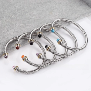 Macro detail of stainless steel cable bracelets with colorful faceted gemstone ends