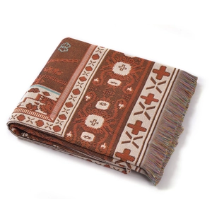 Detail of woven camping blanket with ethnic geometric patterns and colorful tassels
