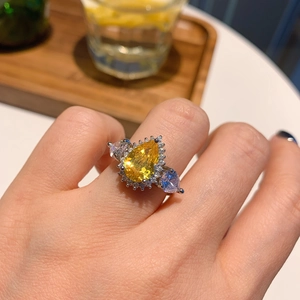 Elegant vintage yellow pear-cut gemstone ring with silver band worn on a finger