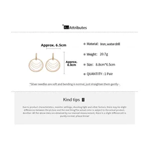 Détail de boucles d'oreilles dorées à pampilles avec tiges en argent et strass taille 8,8cm