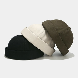 Three cotton docker hats in black, beige, and army green with a minimalist brimless design