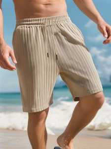 Detail of khaki men's striped shorts featuring textured crinkle fabric and drawstring waist