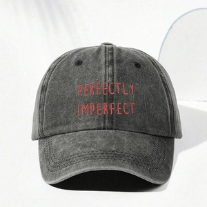 Washed black denim baseball cap with red Perfectly Imperfect embroidery and adjustable strap