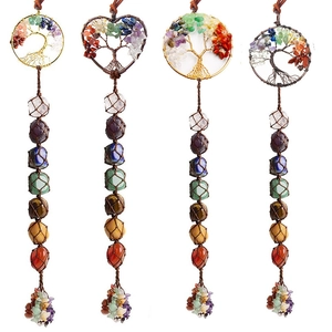 Detailed shot of tree of life pendants with colorful crystals and chakra stone beads