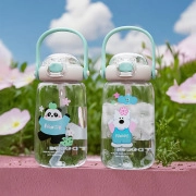 Close-up of cute panda and bear cartoon glass cups with straws in outdoor scenery
