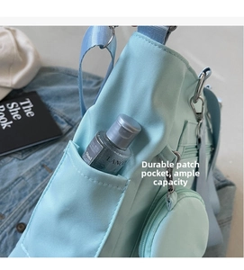 Detail of light blue canvas bag side pocket with round coin purse and skin care bottle