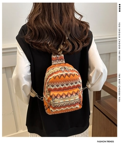 Detail shot of a bohemian woven orange chest bag worn by a model in a casual setting