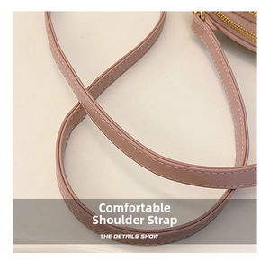 Detail of pink PU leather shoulder strap with white double stitching and gold zipper