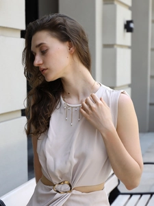 Détail du collier en acier plaqué or 18 carats avec d'élégants pompons en perles blanches