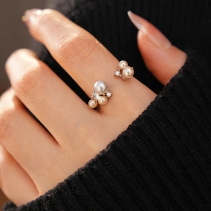 Detailed close-up of adjustable cluster ring with zircon and shell pearls on hand