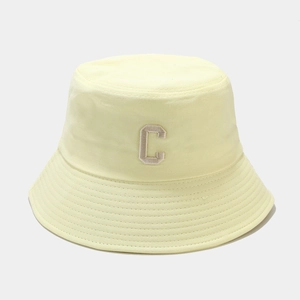 Détail de couture sur un chapeau bob jaune clair avec broderie de la lettre C élégante