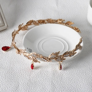 Detail of golden leaf crown with sparkling rhinestones and red teardrop gemstones