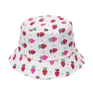 Close-up of strawberry embroidery and green polka dots on white cotton bucket hat