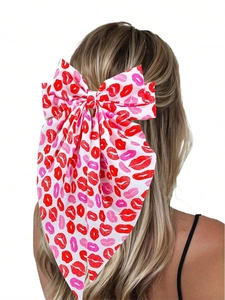 Detail view of large bow hair clip with red lip print on long ribbon for women