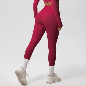 Detail view of high-waisted peach-lift yoga pants and cropped top in deep rose red