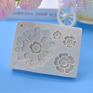 White silicone mold featuring detailed daisy flower patterns for fondant and cake decoration