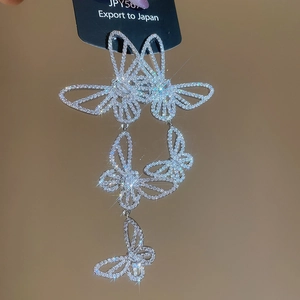 Macro shot of silver butterfly drop earrings with shimmering cubic zirconia stones